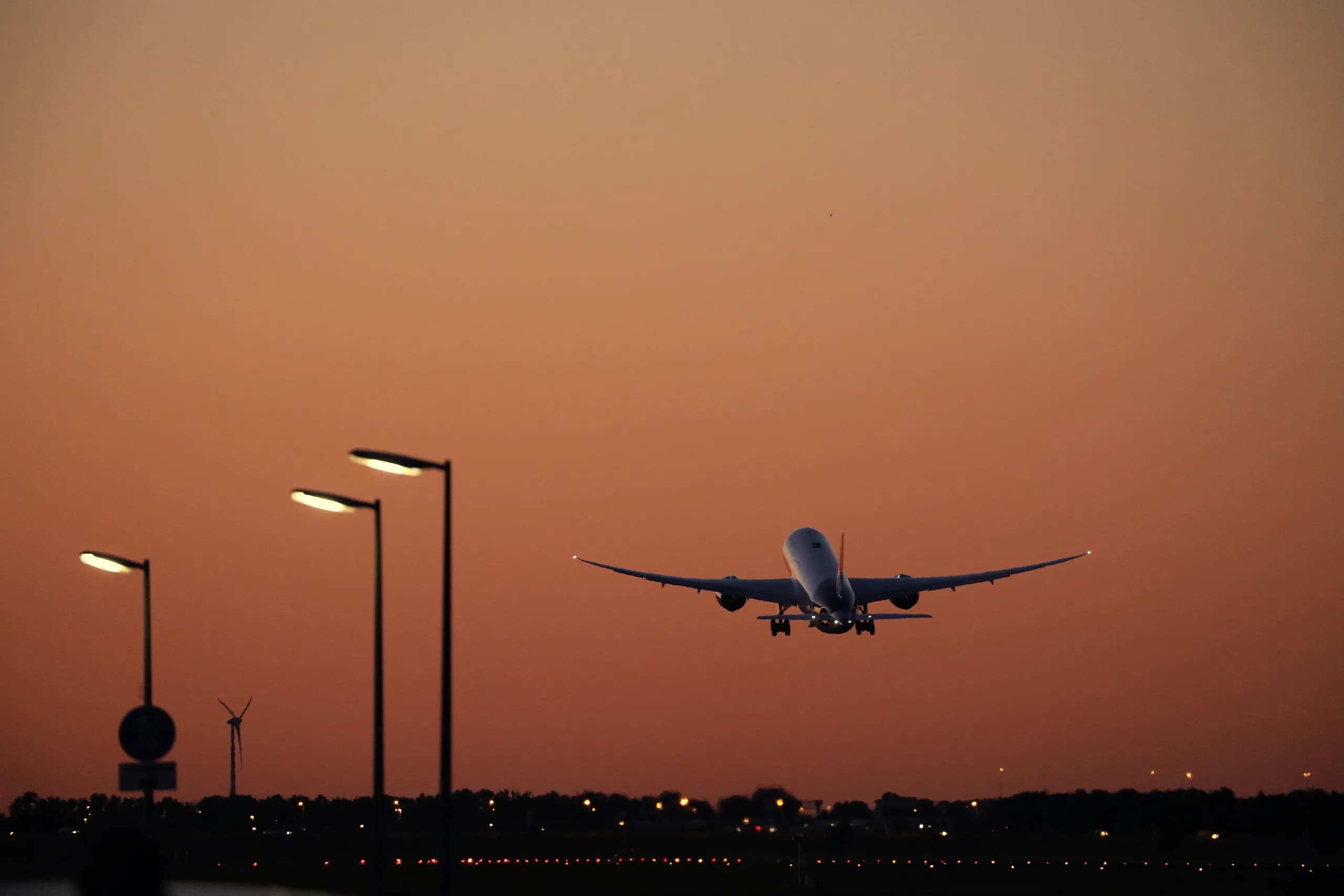 A plane taking off into the sunset